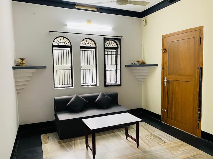 Living room with sofa, table, and arched windows