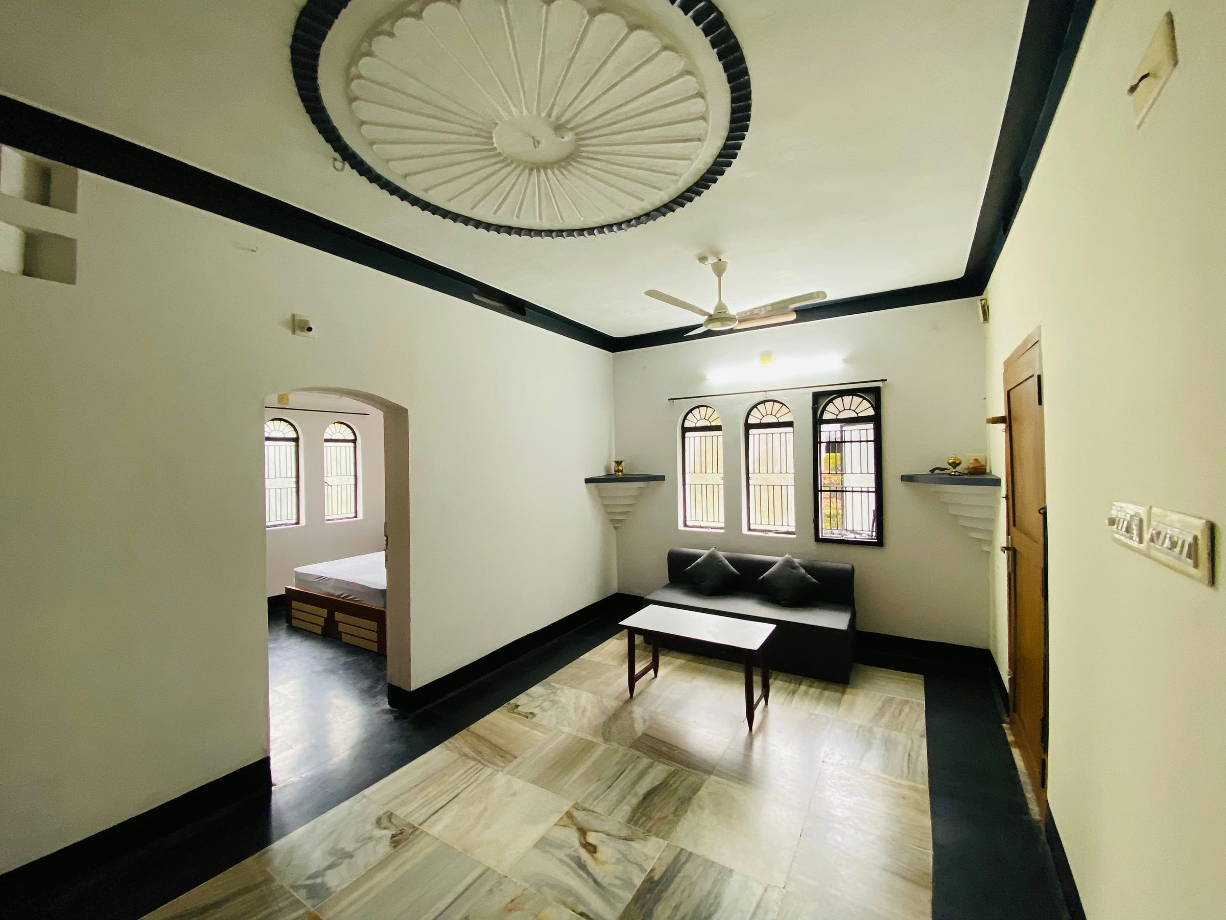 Light-filled sitting room with arched windows and a ceiling fan
